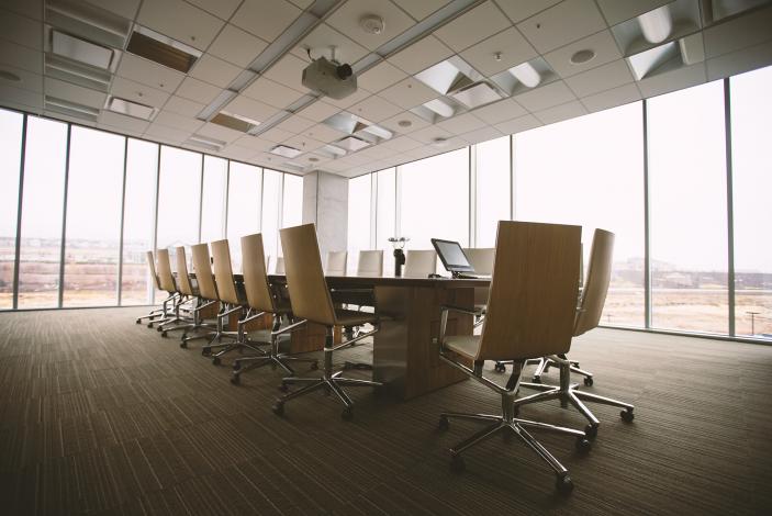 Image: Conference room with chairs and a large table, light streaming through the windows